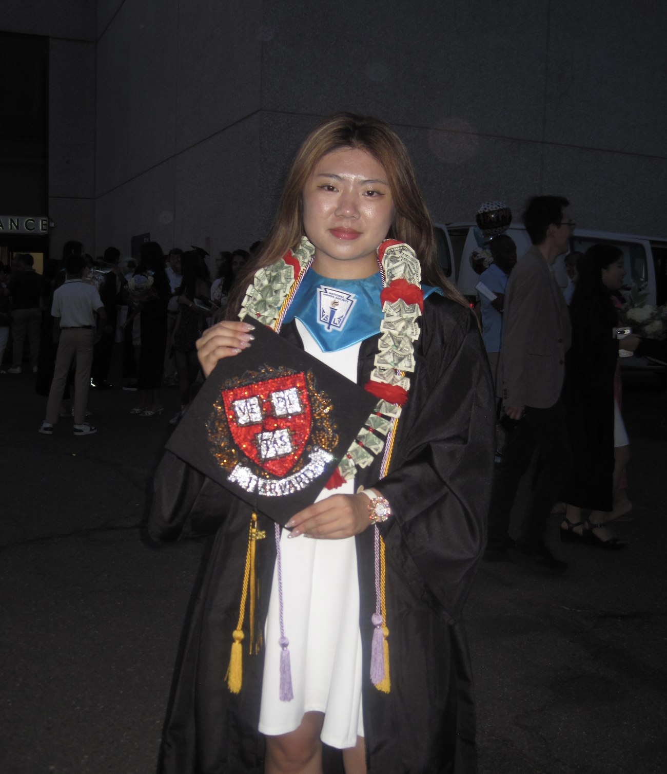 Claire Jiang at her high school graduation, holding a decorated cap
