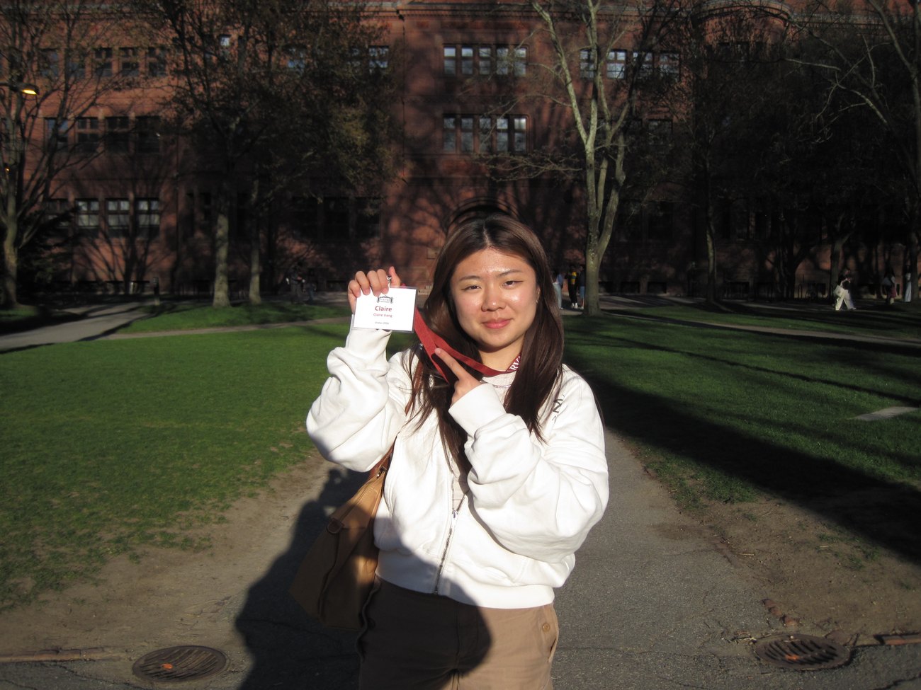 Claire Jiang holding her Visitas name badge in Harvard Yard